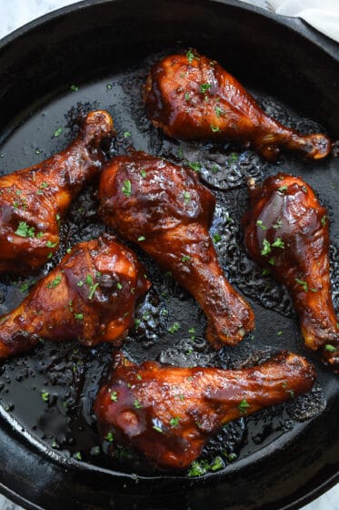Cast Iron BBQ Chicken-Are you tired of having the same old chicken drumsticks? The flavor is always the same and the meal is just average. If so, then you need to try these baked bbq chicken drumsticks. They are juicy, delicious, full of flavor, perfectly glazed, sweet, sticky, and simple to make. You only need one pan to make them, too.